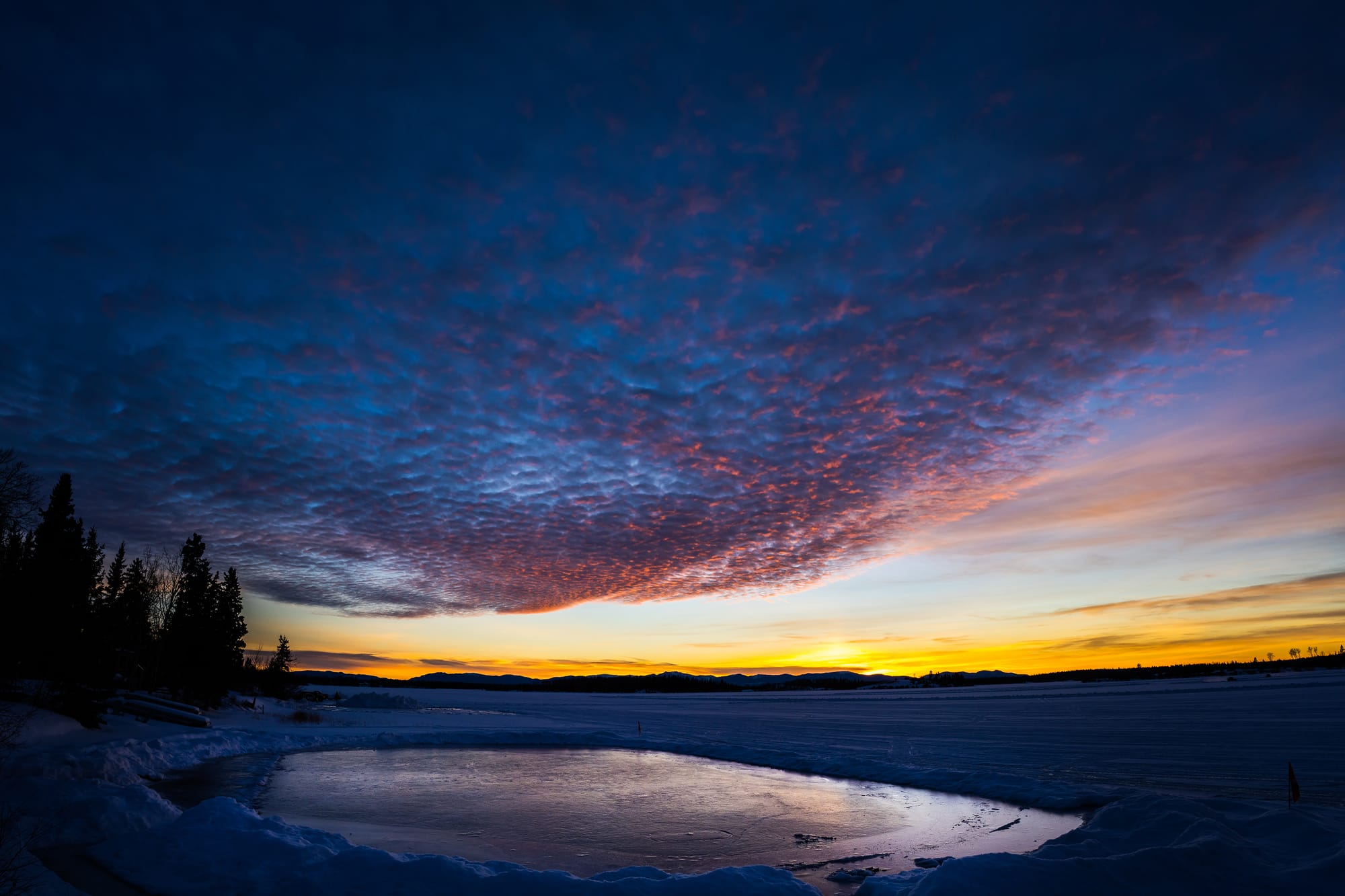 Winter sunset over a frozen Green Lake with a hand-cleared skating rink in the foreground